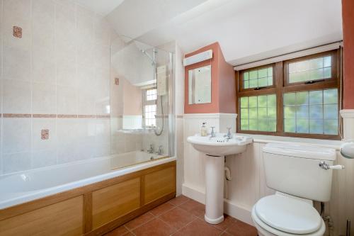 a bathroom with a toilet and a sink and a tub at Tom Callows - Gorgeous Rural Cottage in Epwell! in Epwell