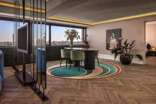 a living room with a table and chairs and a large window at Cardo Brussels, Autograph Collection in Brussels