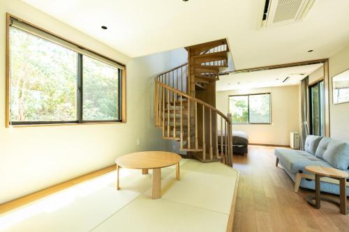 a living room with a spiral staircase and a table at Nokoshima Island Park Villa Sakimori in Fukuoka