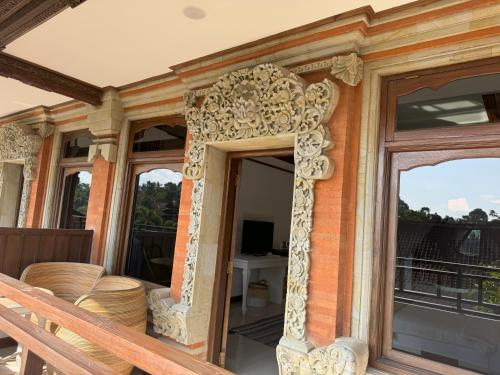 a porch of a house with a wooden door at Chakra Living Ubud in Ubud