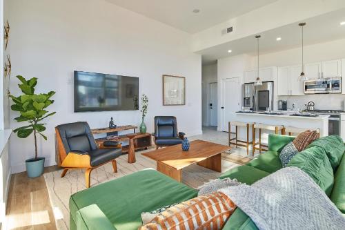 a living room with a green couch and a table at Prime Hoboken Lofts in Hoboken