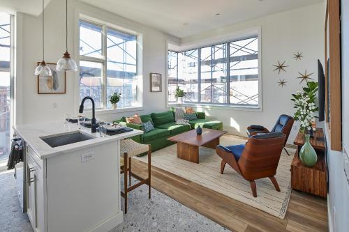 a kitchen and living room with a green couch at Prime Hoboken Lofts in Hoboken
