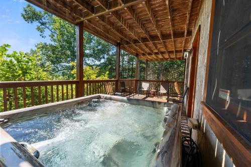 a hot tub on the deck of a house at Eagles Point Cabin in Park Settlement