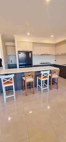 a kitchen with a table and two chairs and a counter at Stay in Tarneit West Melbourne in Tarneit