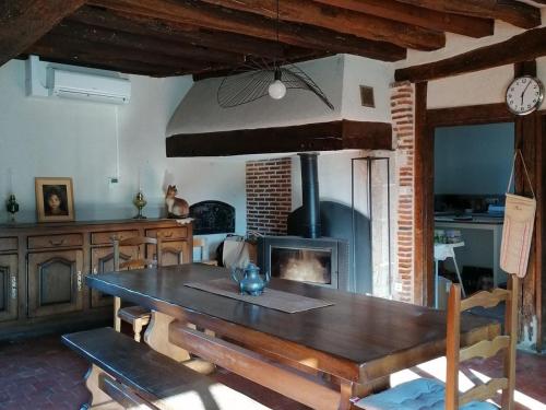 une salle à manger avec une table et une cheminée dans l'établissement Gîte de charme en forêt: 4/6 pers, nature, détente, parking, animaux acceptés - FR-1-590-529, à Saint-Firmin-sur-Loire