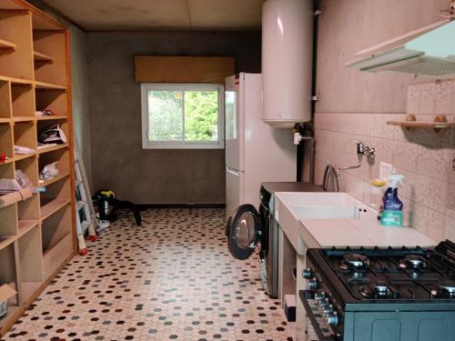 une petite cuisine avec un évier et une cuisinière dans l'établissement Maison calme proche plage, jardin, wifi, animaux sur demande - FR-1-306-1290, à Mesquer