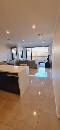 a large room with a lobby with tables and chairs at Stay in Tarneit West Melbourne in Tarneit