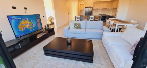 a living room with a white couch and a tv at Stay in Tarneit West Melbourne in Tarneit