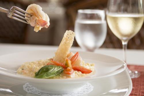 a plate of food with a fork and a glass of wine at Baldi Hot Springs Hotel & Spa in Fortuna