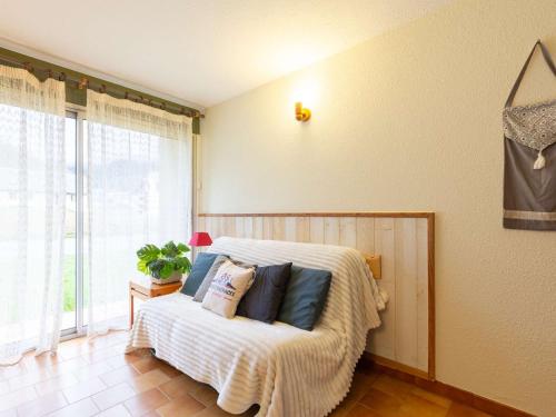 une chambre avec un lit avec des oreillers dessus dans l'établissement Appartement calme proche centre Saint-Lary avec parking et navette gratuite - FR-1-296-509, à Saint-Lary-Soulan