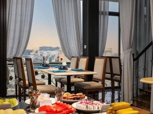 a table with food on a balcony with a view at Hanoi Dalvostro Valentino Hotel & Spa in Hanoi
