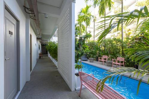 a corridor of a building with a pool and plants at Ang Pao Hotel Phuket in Phuket Town