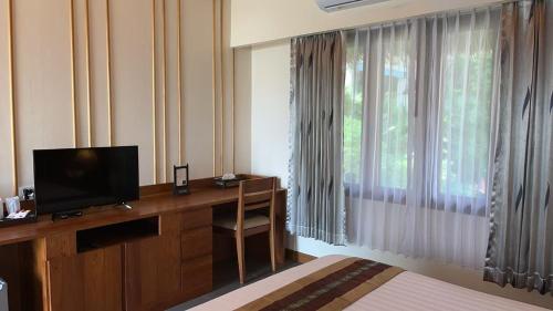 a room with a desk with a television and a window at Better View Koh Yao Yai in Ko Yao Yai