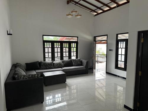 a living room with a couch and two windows at Zuulas Palace in Dickwella
