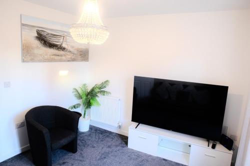 a living room with a flat screen tv and a chair at Newcastle Upon Tyne View Haven in Newcastle upon Tyne