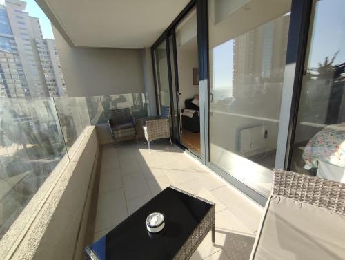 a view of a balcony with a watch on a table at Departamento nuevo full amoblado con espectacular vista a las dunas in Concón