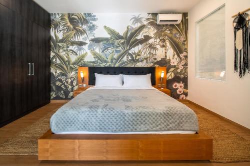 a bedroom with a large bed with a floral wallpaper at Villa Sound Canggu in Mengwi