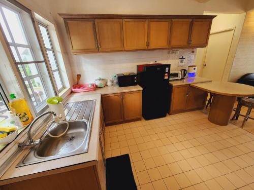 a small kitchen with a sink and a refrigerator at Little England B8 in Bukit Fraser