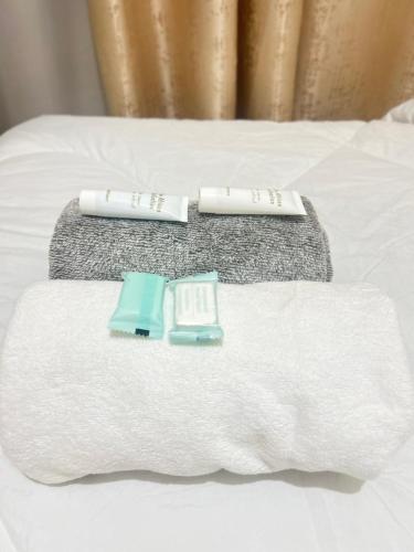 two towels and toothbrushes sitting on top of a bed at Nana Suites 1-bedroom with Swimming pool & Fast WiFi & Mall in Nairobi