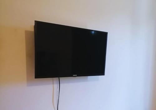 a flat screen tv hanging on a wall at Depa a 3 min de Plaza Portales in Veracruz