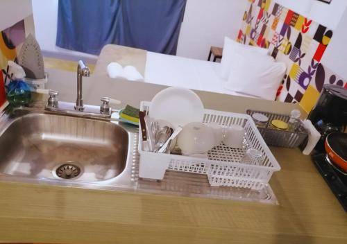 a kitchen sink with dishes in a dish drying rack at Depa a 3 min de Plaza Portales in Veracruz