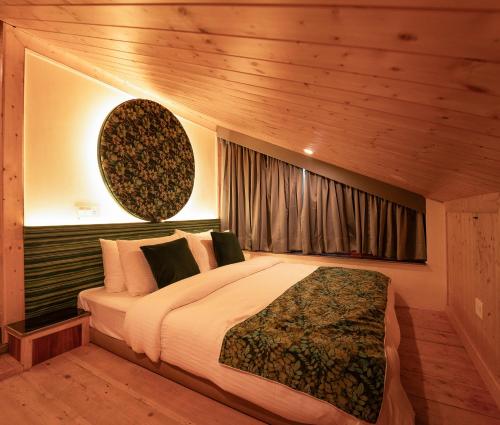 a bedroom with a large bed and a window at Nazaara - A Luxe Retreat in Manāli