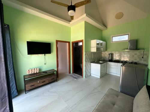 a kitchen with green walls and a flat screen tv at Thip Siam Village in Ao Nam Mao