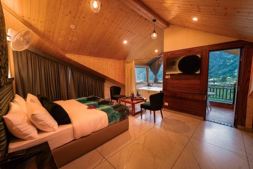 a bedroom with a bed and a desk and a window at Nazaara - A Luxe Retreat in Manāli