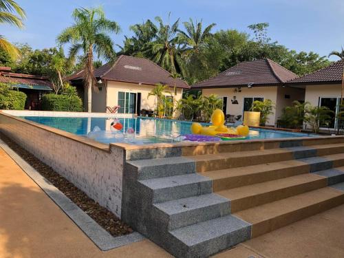 a swimming pool with a slide in front of a house at Thip Siam Village in Ao Nam Mao