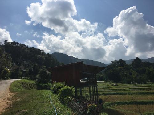 a small building in a field next to a road at Mukakee in Ban Sop Mae Klang