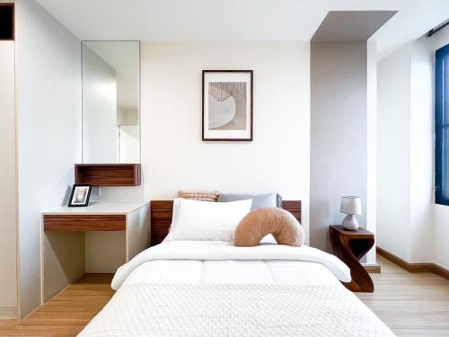 a bedroom with a bed with a desk and a mirror at The Gallery Bearing in Samut Prakan