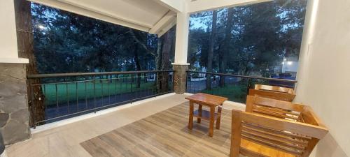 a balcony with two chairs and a large window at Villa 2Cemara in Batureo 1