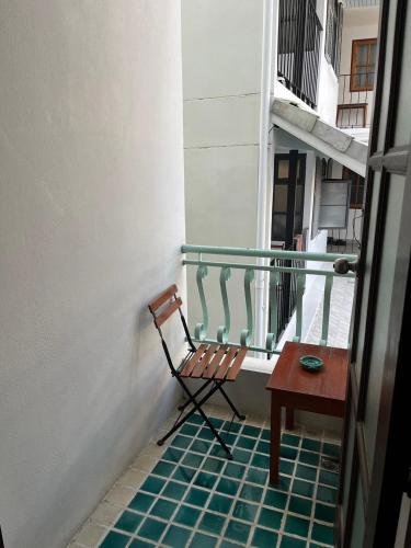 a chair sitting on a balcony with a table at Sripat Guesthouse SHA Extra Plus in Chiang Mai
