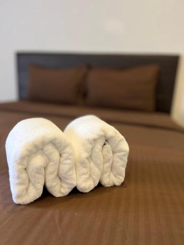 a roll of white towels laying on a wooden floor at Noza INN in Khao Lak