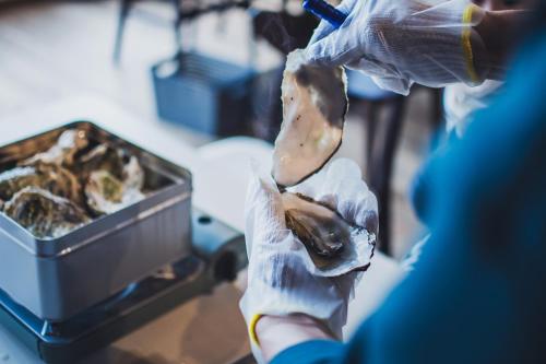 a person in gloves holding a piece of food at 【佐渡/一棟貸切】オーシャンビュー古民家SeaSideStory椿 離れ in Sado
