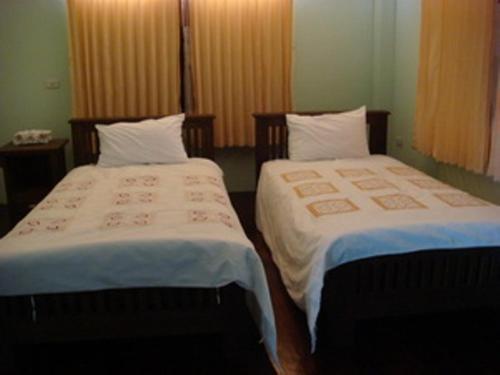 twee bedden naast elkaar in een kamer bij Keerawan House Rim Khong in Ban Wat Luang