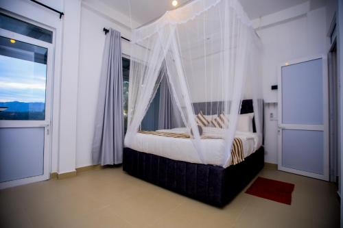 a bedroom with a canopy bed with a window at Ella Nimal Nest Inn in Ella