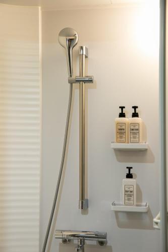 a bathroom with two soap dispensers on a shelf at 藍-Ai-ASAKUSA in Tokyo