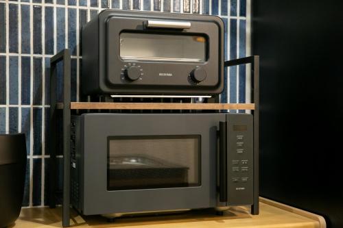a microwave and a toaster oven sitting on top of a toaster oven at 藍-Ai-ASAKUSA in Tokyo