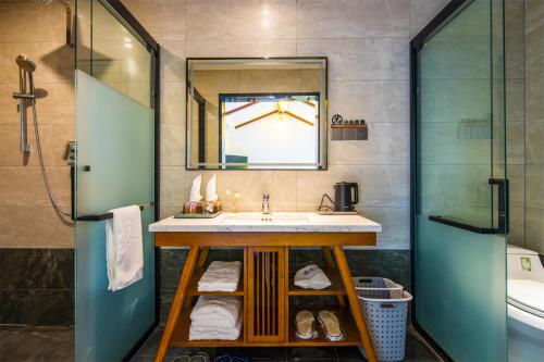 a bathroom with a sink and a mirror at Summergarden Hotel in Wolongguan