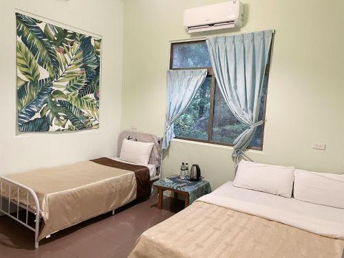 a room with two beds and a window at 森霖旅宿 in Meinong