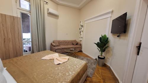 a bedroom with a bed and a chair and a television at downtown Family Suites in Cairo