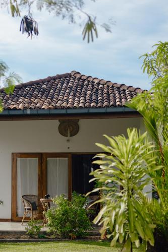 a house with a roof with a table and chairs at Emel's Retreat By Tropical Magnum - Luxury Boutique Villa in Anhandigoda