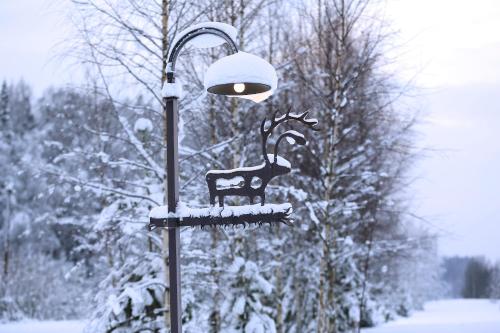 a street light with a deer on it in the snow at Viesu mājas Briedīši in Raiskums