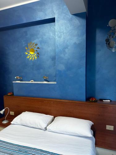 1 dormitorio con una pared azul y 1 cama en La Dea del mare, en Scilla