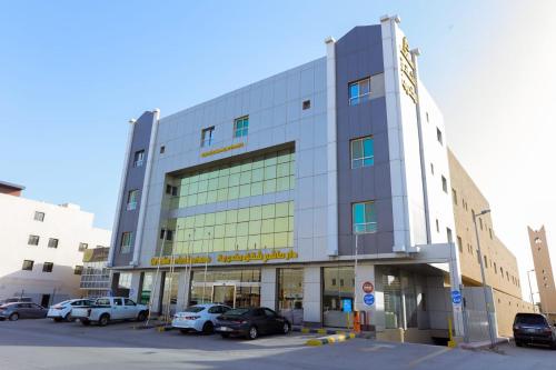 a large building with cars parked in a parking lot at Dar Hashim Serviced Apartments Al Morouj - Economic in Riyadh