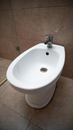 a white toilet in a bathroom with a sink at Consul Hotel in Baku