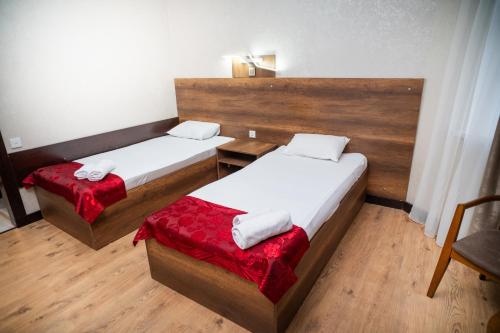 a room with two beds and a chair in it at Consul Hotel in Baku