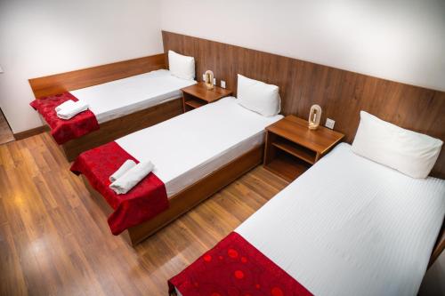two beds in a small room with red accents at Consul Hotel in Baku