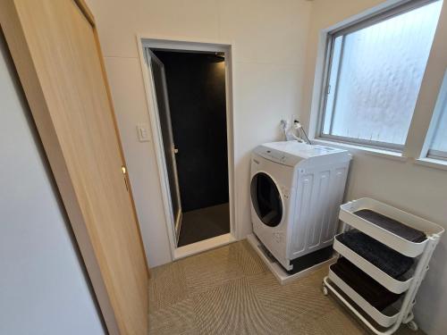a laundry room with a washing machine and a window at 三笠館Mikasakan 別館 in Kinokawa